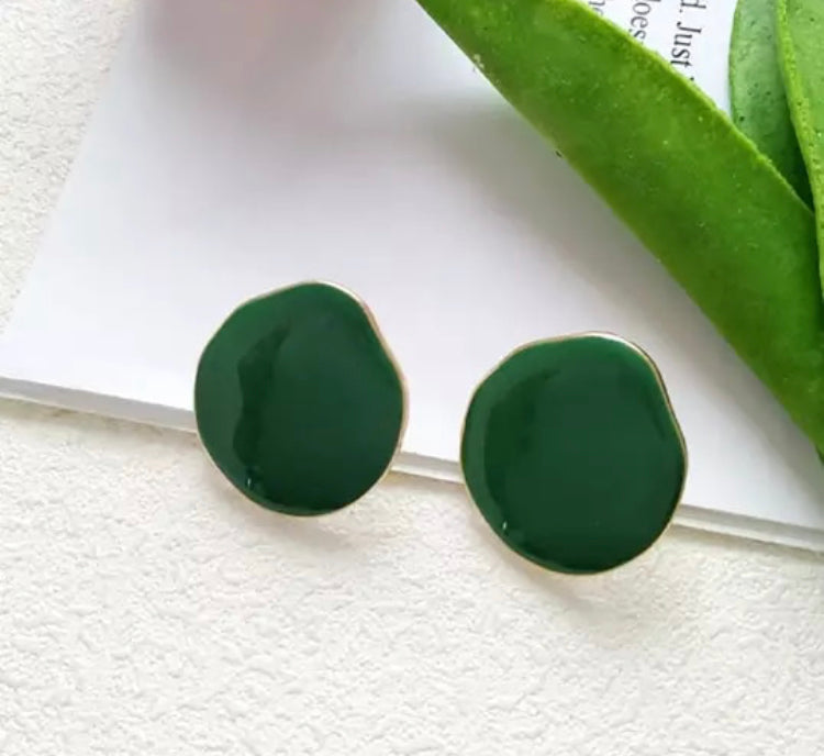 A simple, medium sized flat stud with a drip texture and fine gold trim.