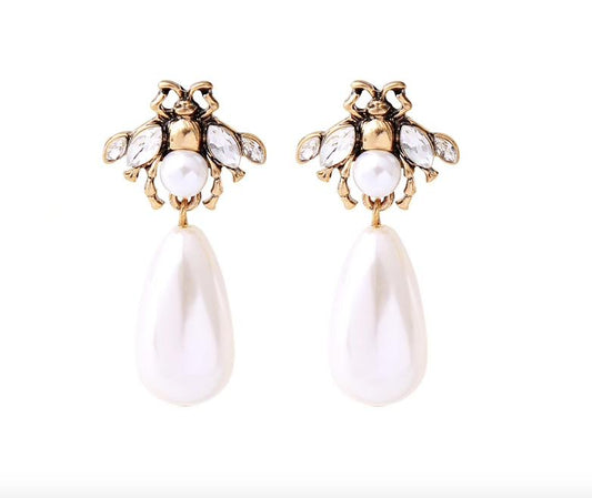 A small and detailed bug stud in vintage gold, faux pearl and clear crystals, complimented by a large faux pearl drop.