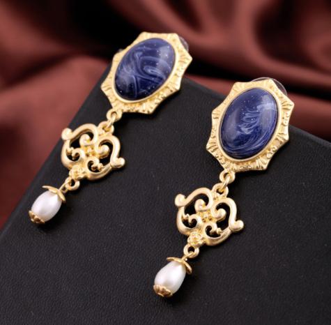 A beautiful oval shaped navy marbled stud complimented by an intricate golden border which transcends into a gold filigree drop and ends in a single simple pearl. Lightweight and beautifies a classic look.