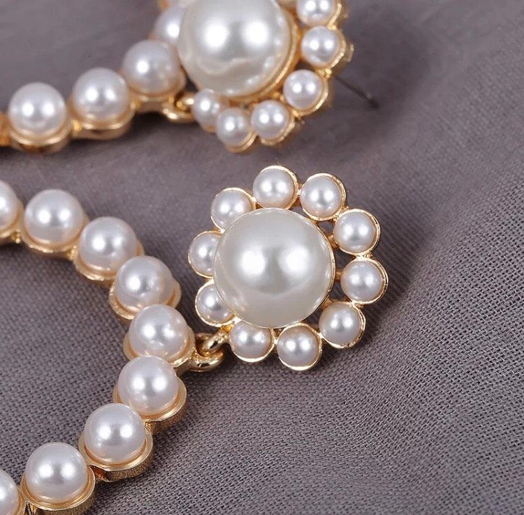 A simple yet beautiful pearl circular drop with a flower shaped stud. A true statement style and very versatile. Lightweight.