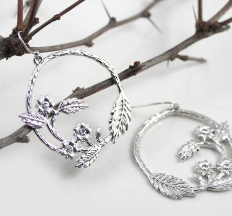 A silver floral etched hoop with crystal details.