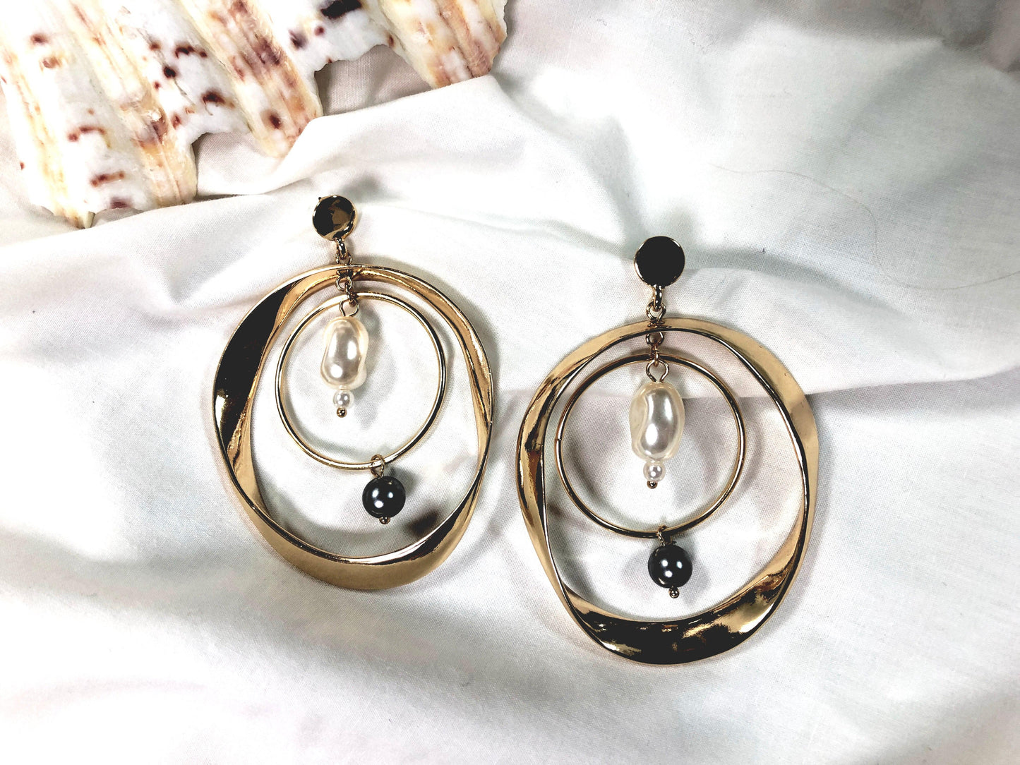 A double gold hoop with white and black pearl detailing.  