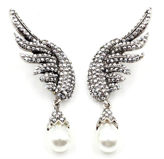 A beautiful crystal encrusted wing design complimented by a simple simulated pearl drop.  The crystal coated wings contour up the ear. They are very unique and an absolutely standout design.  Lightweight enough to wear all night.