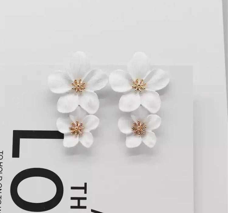 A pretty and bold coloured simple flower stud statement earring with a gold 3D centerpiece.