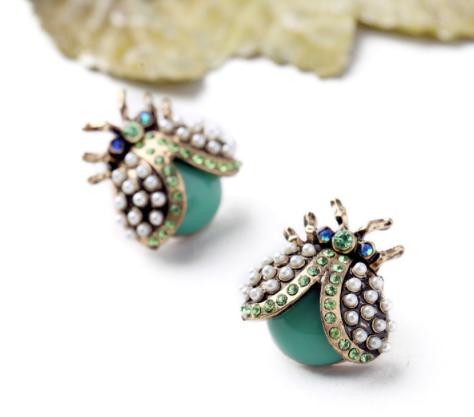 A gorgeous, detailed bug statement stud earring made of vintage gold, miniature pearls, green and blue crystals and a green resin body. A head turning stud with bold colour and unique style.   All earrings arrive beautifully packaged in our luxurious Entire Me pouch. 
