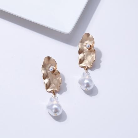 A generous sized pearl like drop attached to an abstract gold plate. 