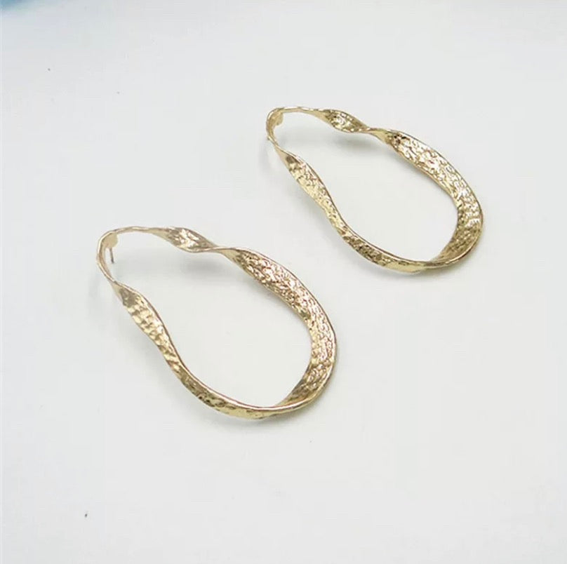 A twisted oblong oversized hoop in gold or silver.