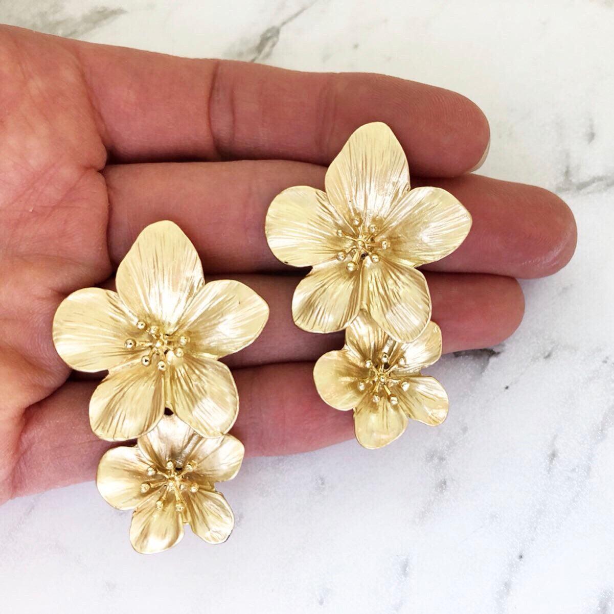A pretty and bold coloured simple flower stud statement earring with a gold 3D centerpiece.
