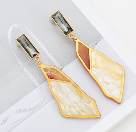 Made from marbled acrylic board in a golden coloured frame and attached to a rectangular deep grey crystal.  Each earring is cut from a single piece of acrylic board, meaning each earring is unique and different.  Like you.