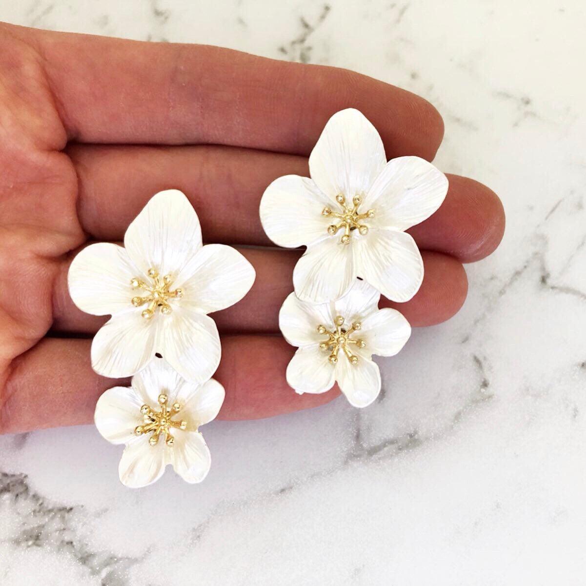 A pretty and bold coloured simple flower stud statement earring with a gold 3D centerpiece.