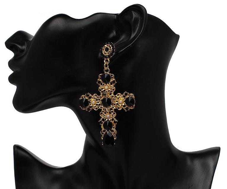 A gold coloured filigree cross with crystal embellishments and tiny faux pearl flower pieces.