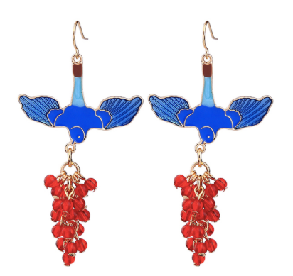 A beautiful blue enamel bird with wings spread and holding a gorgeous bunch of red resin beads from its beak. Framed in vintage gold. Lightweight and unique.