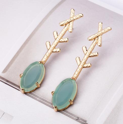 An oval resin drop in a gorgeous green attached to a golden cross arrow design.  Simple and classy.