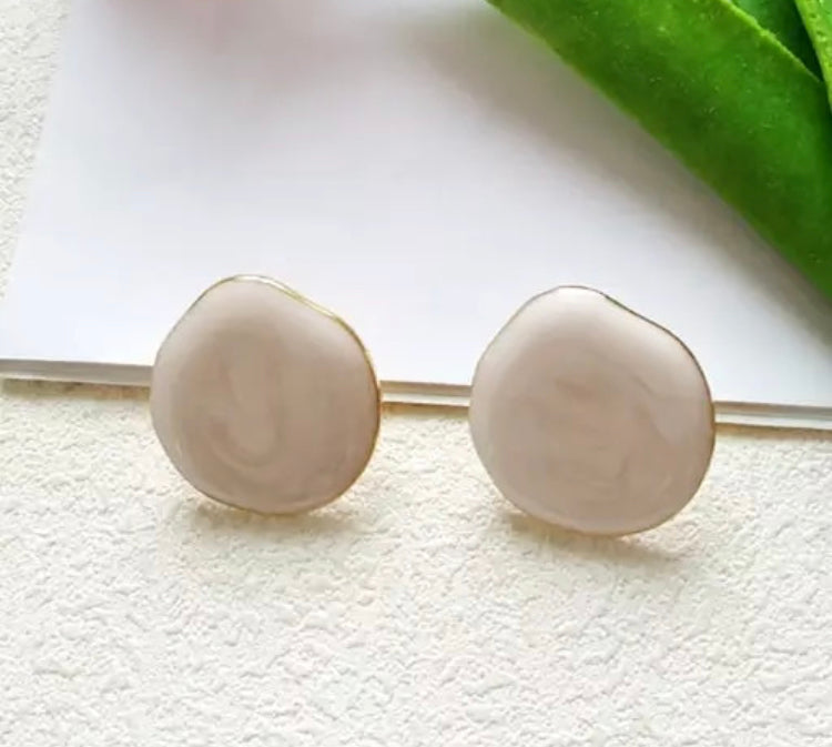A simple, medium sized flat stud with a drip texture and fine gold trim.
