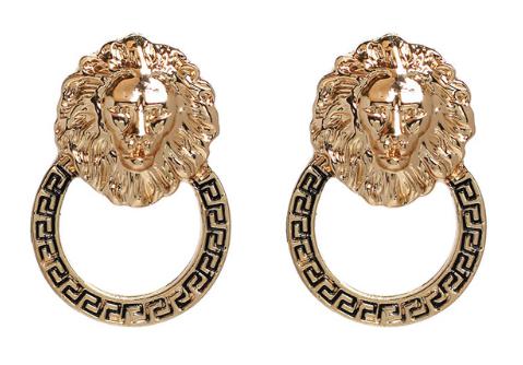 A golden lion head affixed to a circular design with geometric engraving.