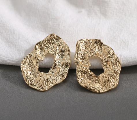 A pressed metal gold oversized stud.  Perfect to day to day wear.