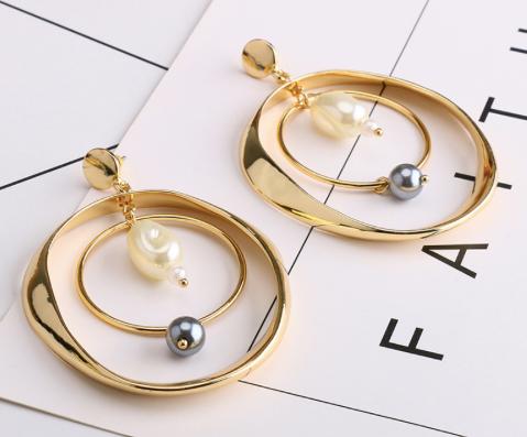 A double gold hoop with white and black pearl detailing.  