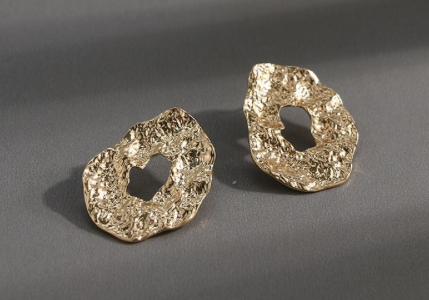 A pressed metal gold oversized stud.  Perfect to day to day wear.