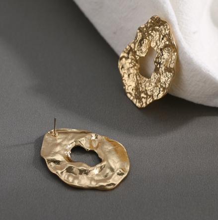 A pressed metal gold oversized stud.  Perfect to day to day wear.