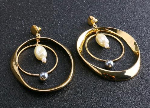 A double gold hoop with white and black pearl detailing.  