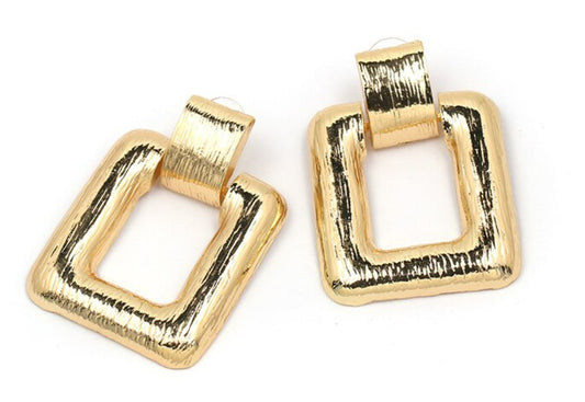 A simple large square drop earring, in either gold or silver, guaranteed to be spoken about.
