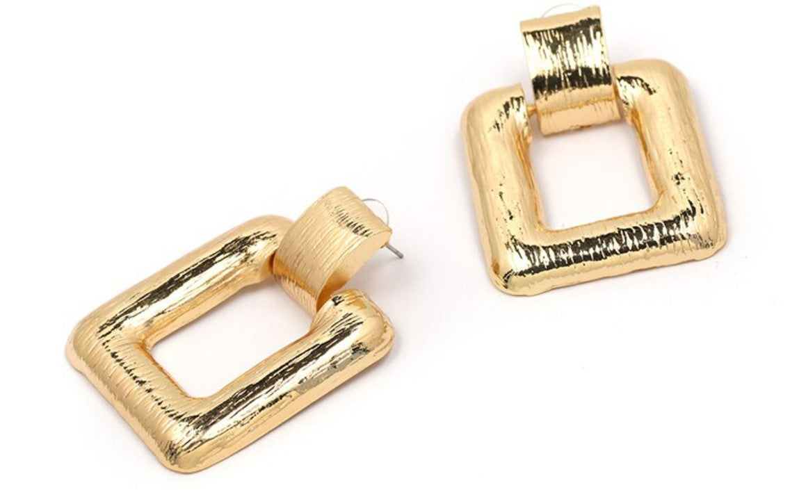 A simple large square drop earring, in either gold or silver, guaranteed to be spoken about.