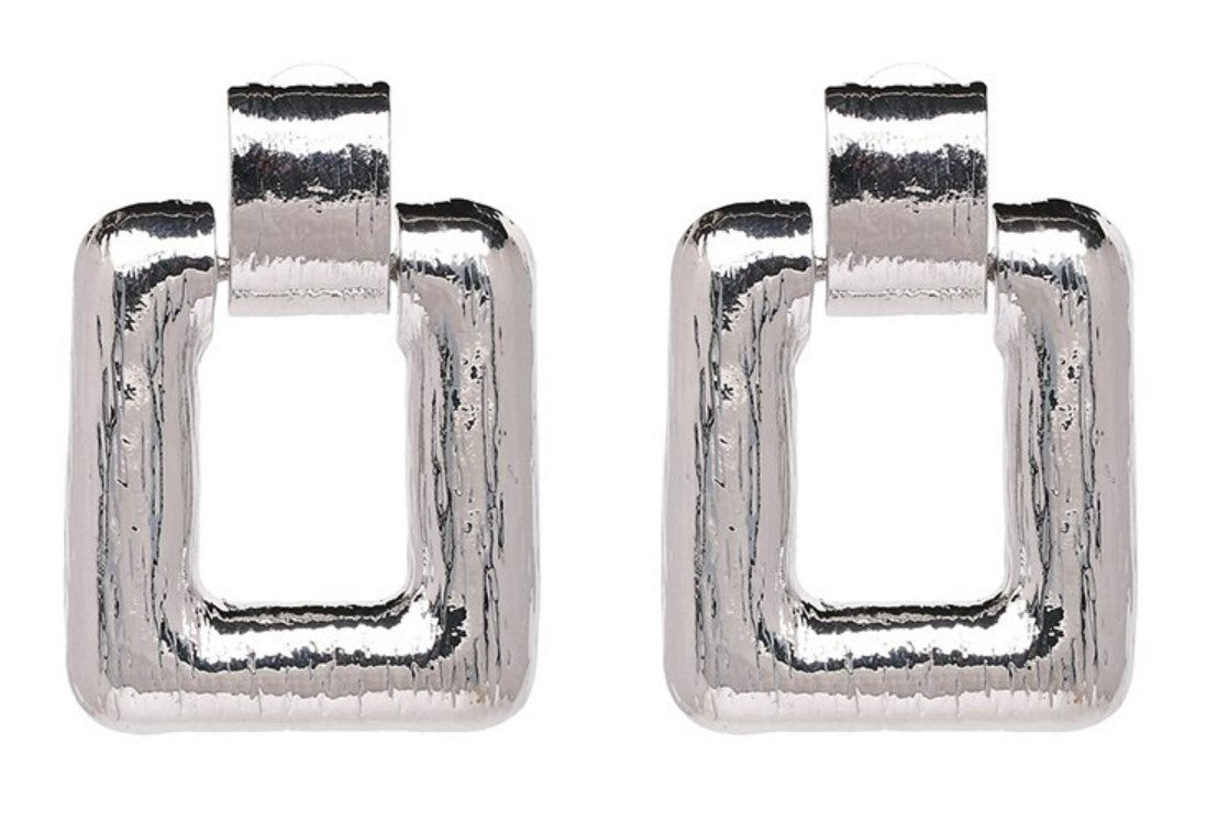 A simple large square drop earring, in either gold or silver, guaranteed to be spoken about.