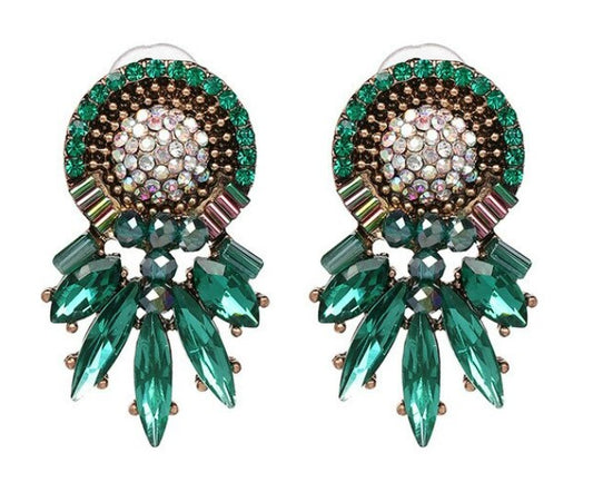  Crafted with sophisticated green tones, these statement studs bring a timeless elegance to any outfit.