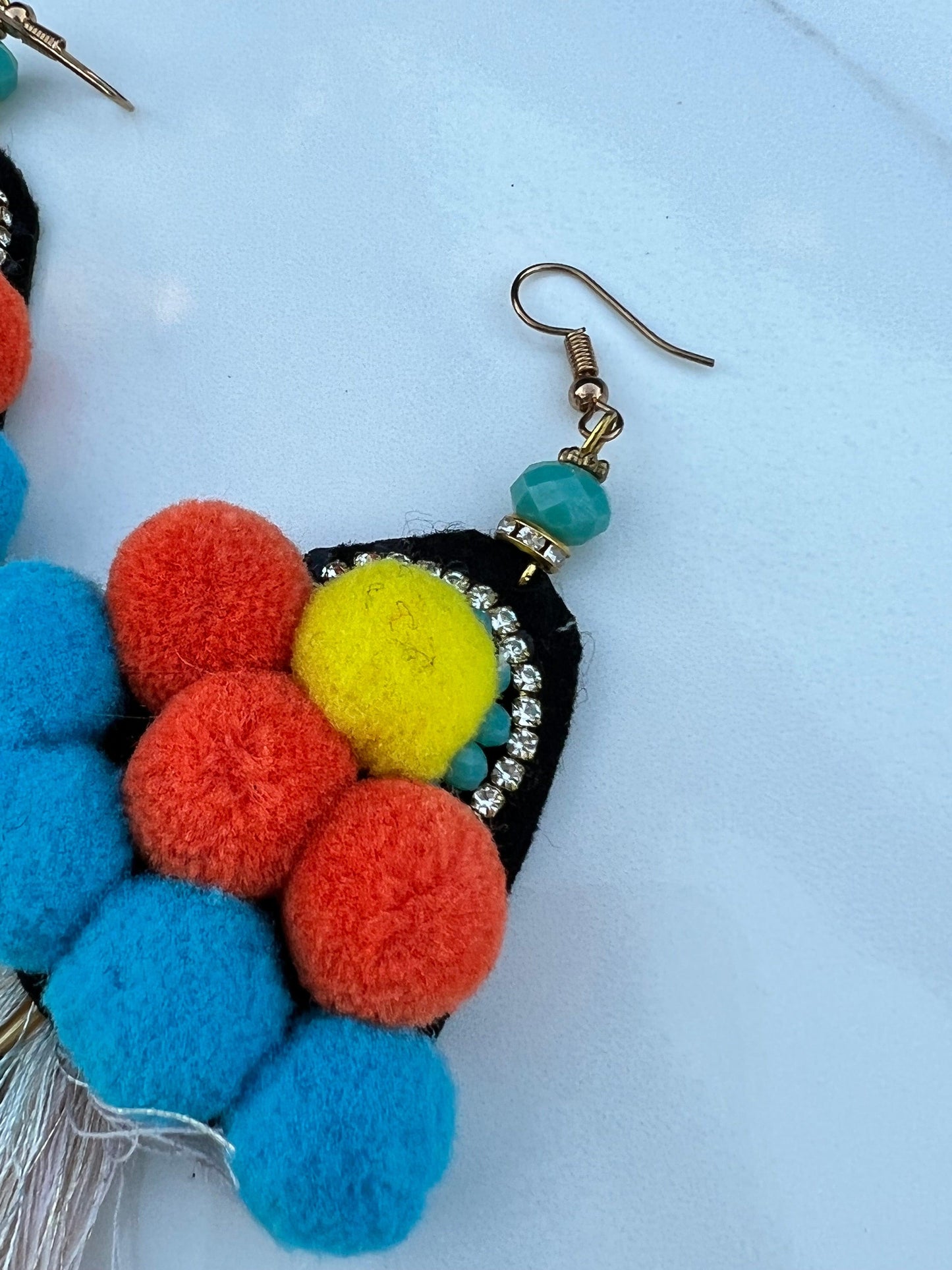 Pom poms, tassels and crystal's all wrapped into one earring!  Vibrant yellows, blues and oranges.    As these are handmade, imperfections could be expected, a true statement