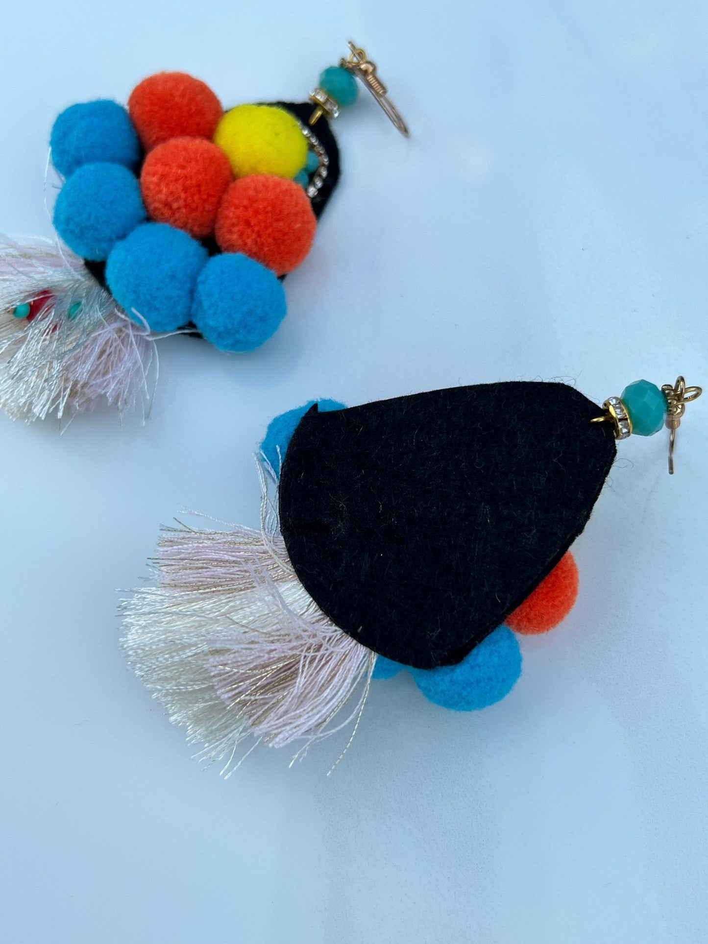 Pom poms, tassels and crystal's all wrapped into one earring!  Vibrant yellows, blues and oranges.    As these are handmade, imperfections could be expected, a true statement