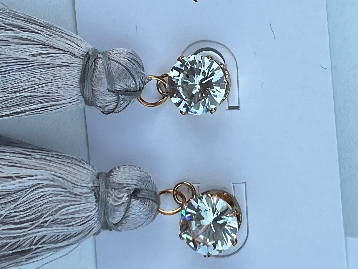 Streamline elegance with this crystal and tassel combination in a gold clasp setting.  Options include Red, Black, Navy & Grey.  Care maybe required with the delicate tassels to ensure shape is maintained, some trimming may be required with wear.    