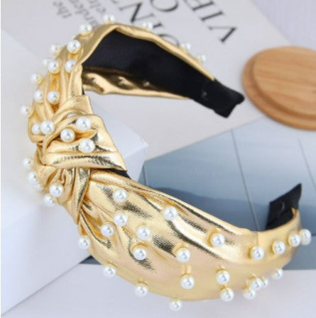 This statement piece exudes sophistication, boasting a knotted wide formation detailed with handcrafted simulated pearls placed on either gold or silver synthetic leather. Perfect for race day chic or a relaxed weekend style, these luxe headbands complete any look.