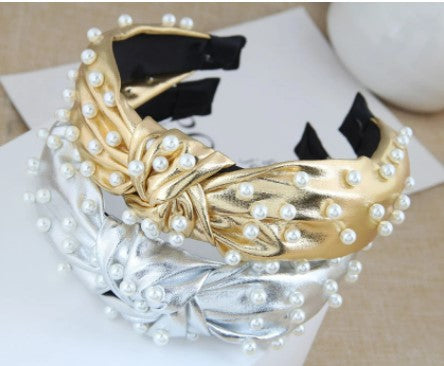 This statement piece exudes sophistication, boasting a knotted wide formation detailed with handcrafted simulated pearls placed on either gold or silver synthetic leather. Perfect for race day chic or a relaxed weekend style, these luxe headbands complete any look.