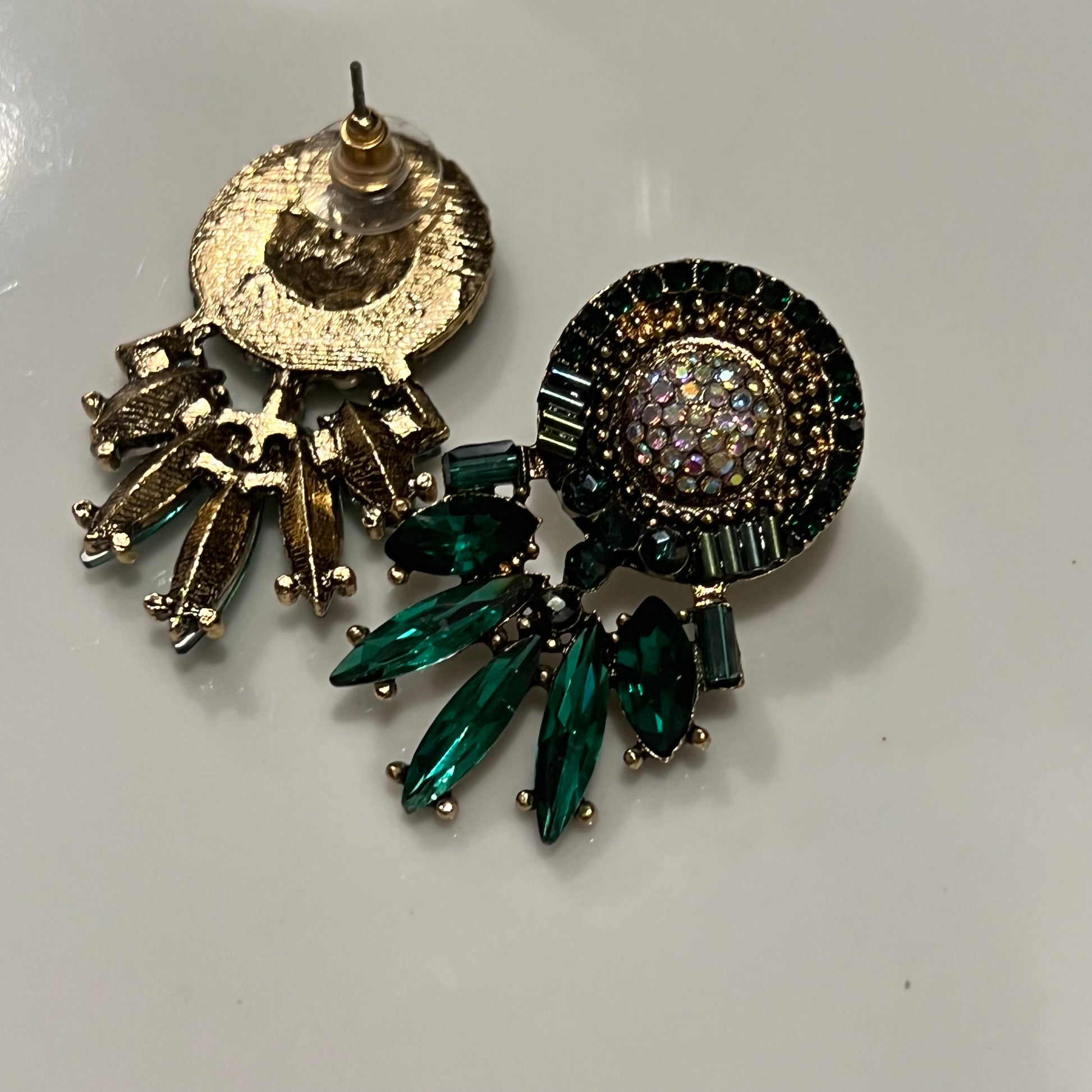  Crafted with sophisticated green tones, these statement studs bring a timeless elegance to any outfit.